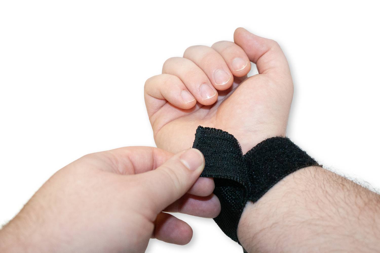 A person is placing a black wrist support around their wrist. The support provides stability and protection.