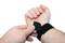 A person is placing a black wrist support around their wrist. The support provides stability and protection.
