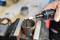 'Close-up of a person working on a metal part in a vice using a rotary tool. Blurred tools in the background.'