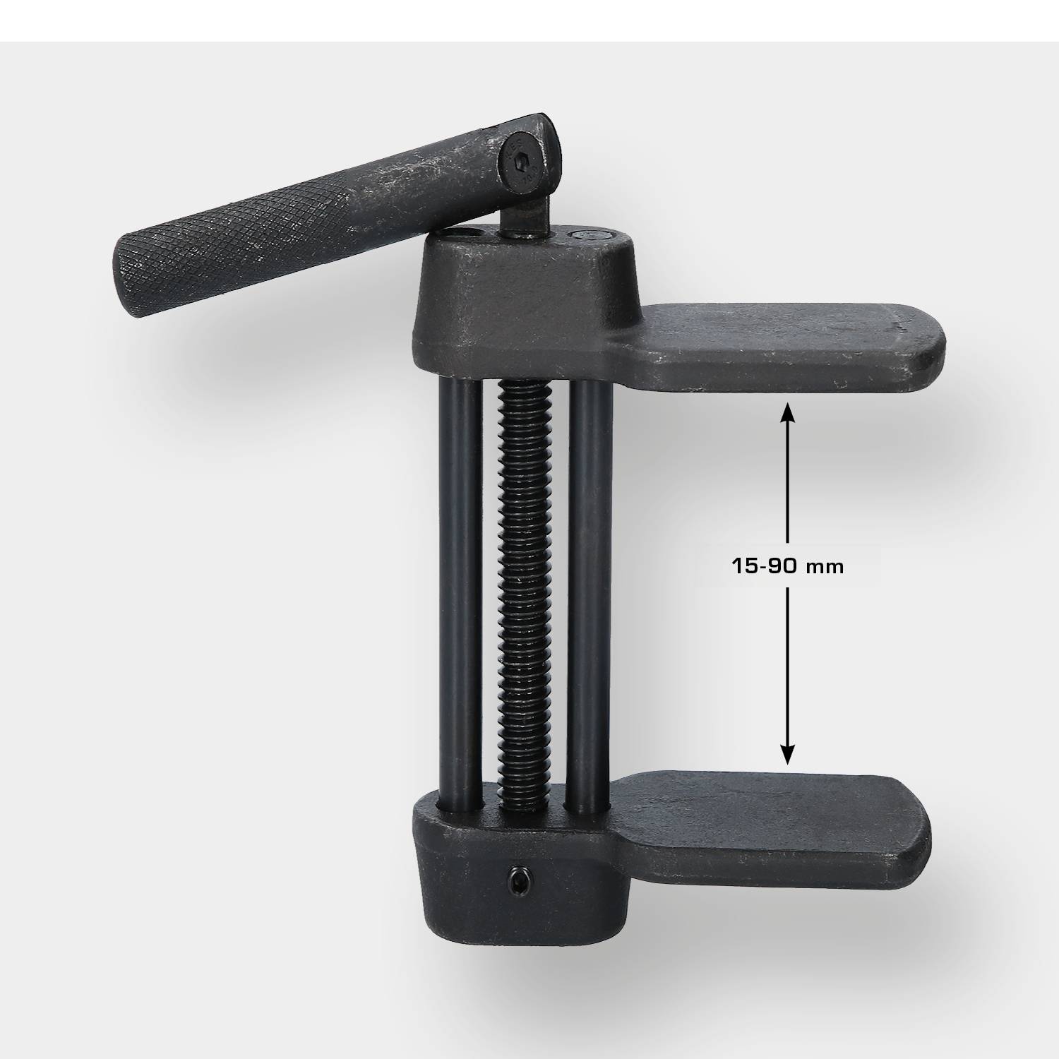 Black G-clamp with a clamping range of 15-90 mm. It has a handle at the top and two parallel jaws for gripping materials.