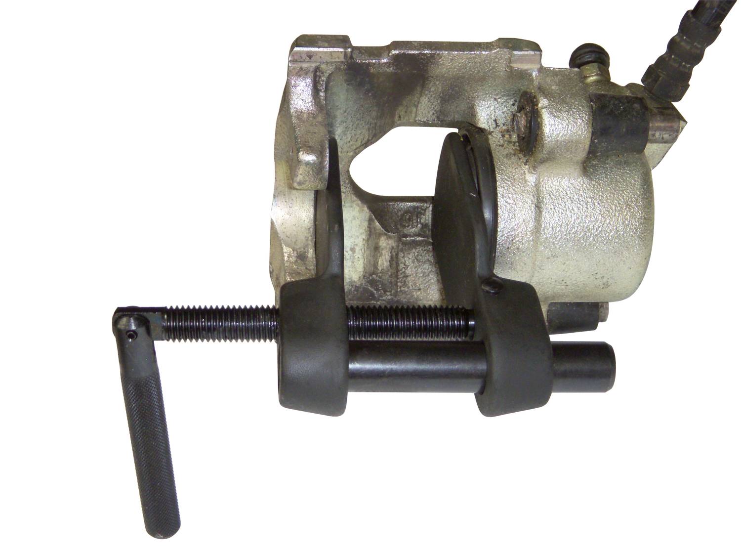 Brake calliper reset tool mounted on a brake calliper. The tool has a handle and a pressure screw for pushing back the calliper piston.