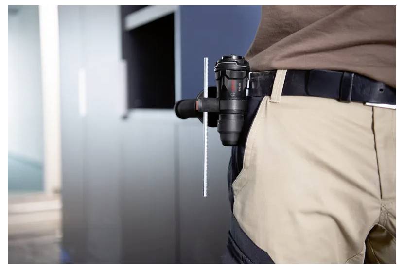 A person with a tool mounted on their belt. The tool appears to be a compact, portable device, suitable for easy access and use.