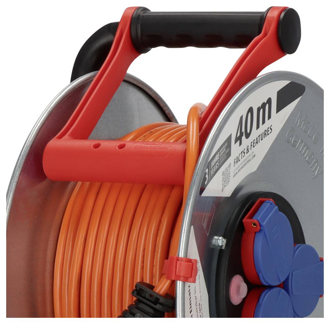 Close-up of a red cable reel with black handle, holding coiled orange extension cord and blue outlets on the side.