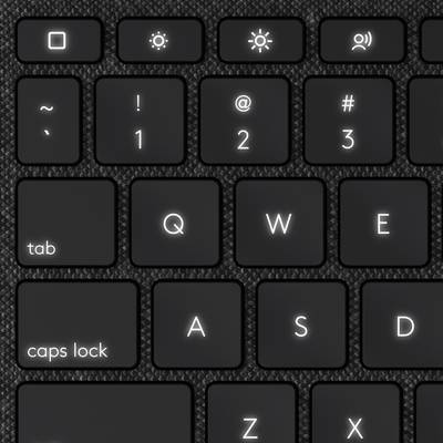 Black computer keyboard with backlighting; shows keys for tab, caps lock and number row with special characters.