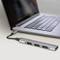 Laptop connected to a USB-C docking station via a cable. The docking station has multiple USB ports.