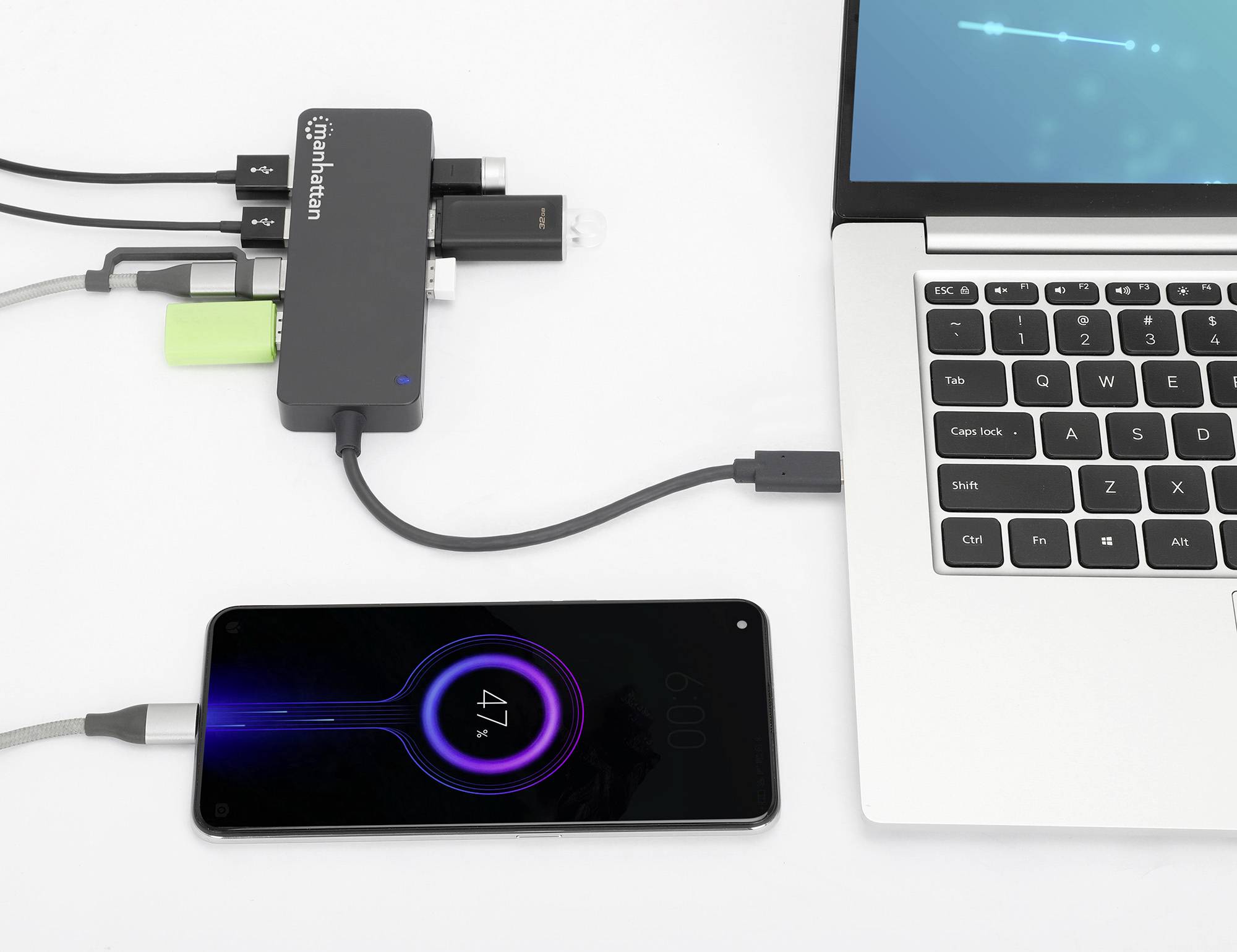A smartphone is being charged via a USB hub from a laptop, with the battery level showing 47%. Multiple devices are connected to the hub.