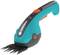An electric garden tool for cutting grass and small shrubs, in turquoise and black, with an ergonomic handle and orange switch.