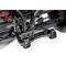 Close-up of a black vehicle chassis. The suspension and parts of the wheel axle are visible. Some red accents are present in the background.