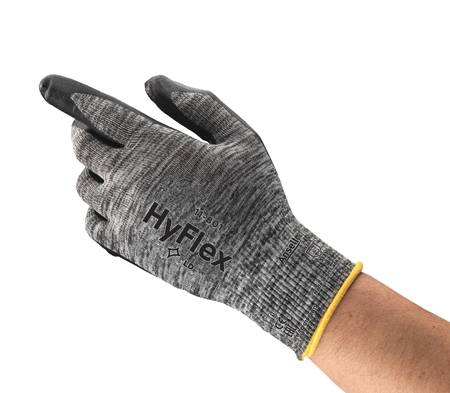 A hand wearing a grey glove that says 'HyFlex' raises two fingers. The glove has black fingertips.