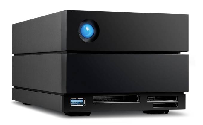A black, cuboid external hard drive enclosure with a brightly illuminated blue button and multiple interfaces at the front.