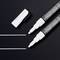 Two white chalk markers with removable caps, lying side by side. One of the markers shows two drawn lines.