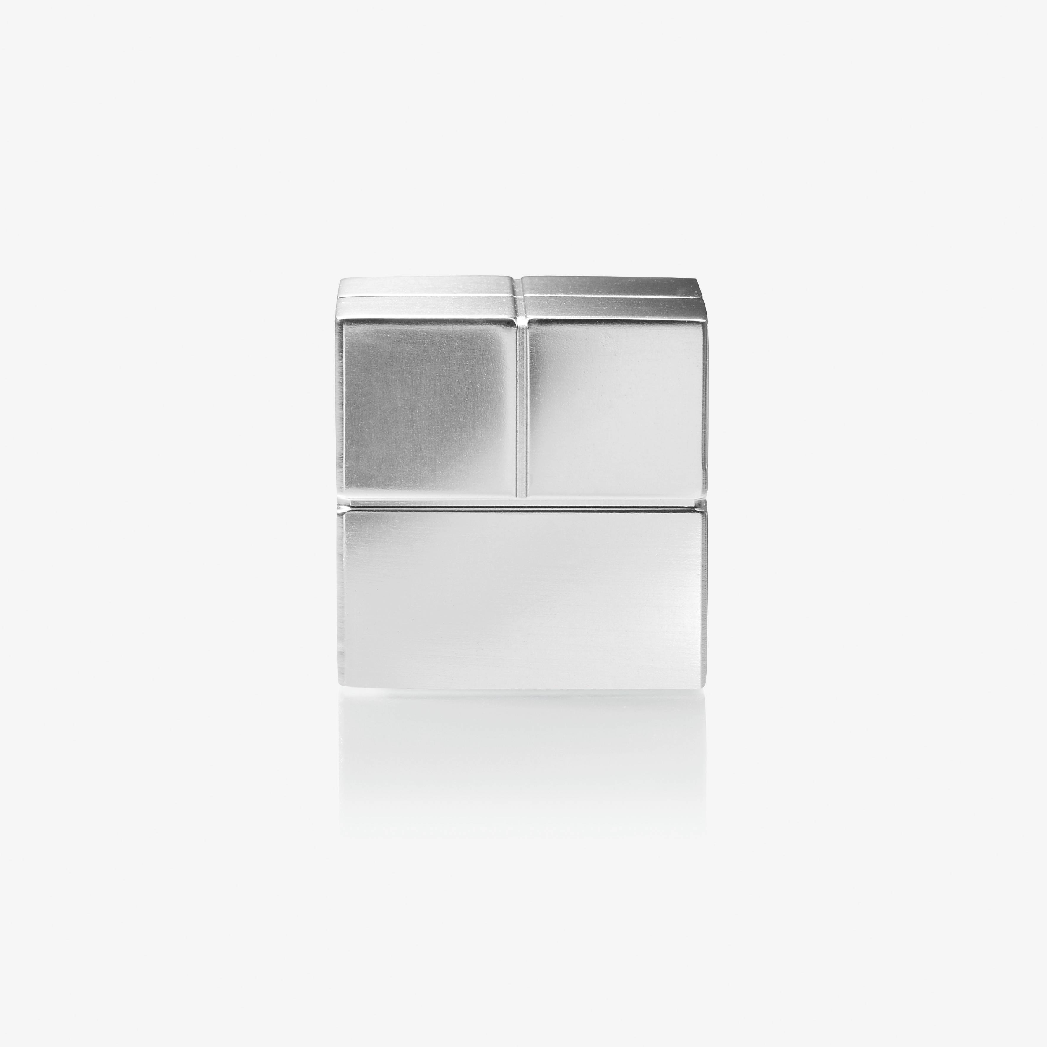 A silver cubic object with four square segments, two on top and two below, arranged on a white background.