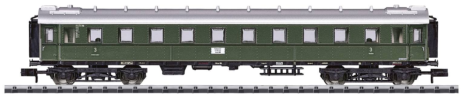 A green, historic railway carriage on tracks, with multiple windows and a silver roof, viewed from the side.