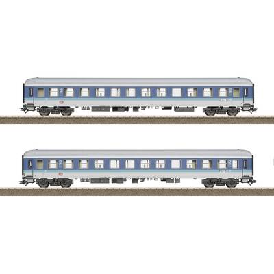 Two blue railway carriages are standing on tracks. The carriages have large windows and are identically designed.