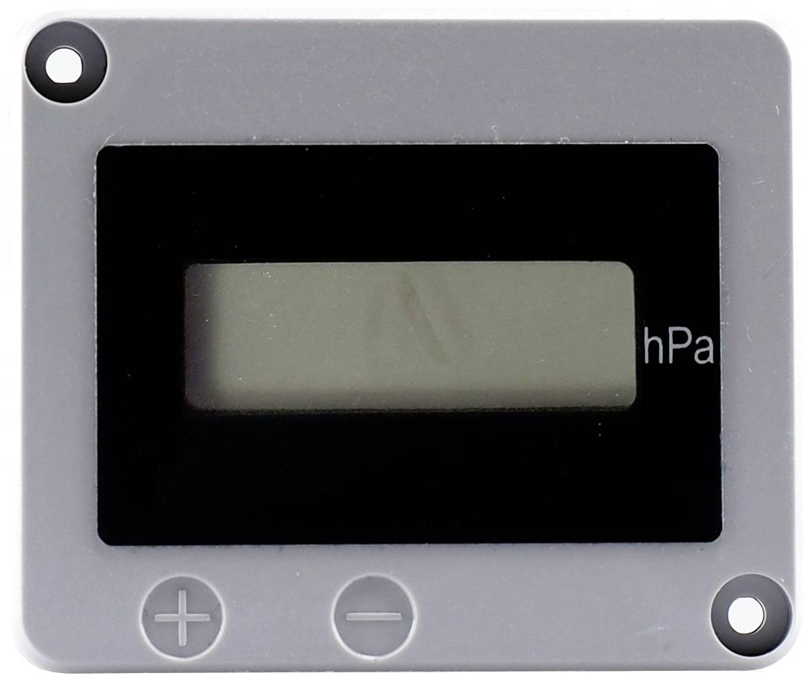 A digital display device with a black screen, faintly showing 'hPa'. Symbols for plus and minus at the bottom left.
