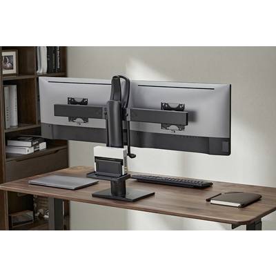 Double computer monitors are mounted side by side on a desk, with a keyboard and a notebook underneath.