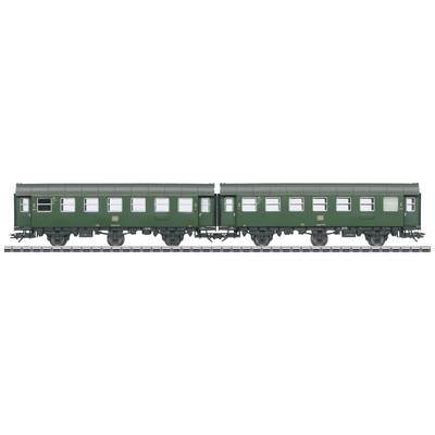 Two green historical railway carriages stand on the same track. Rows of windows are visible. They evoke memories of past passenger trains.