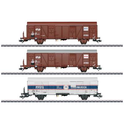 Three goods wagons on rails: two brown with 'NS' logo and one white with 'FRICO' and 'LEEUWARDEN' text, showing different designs.