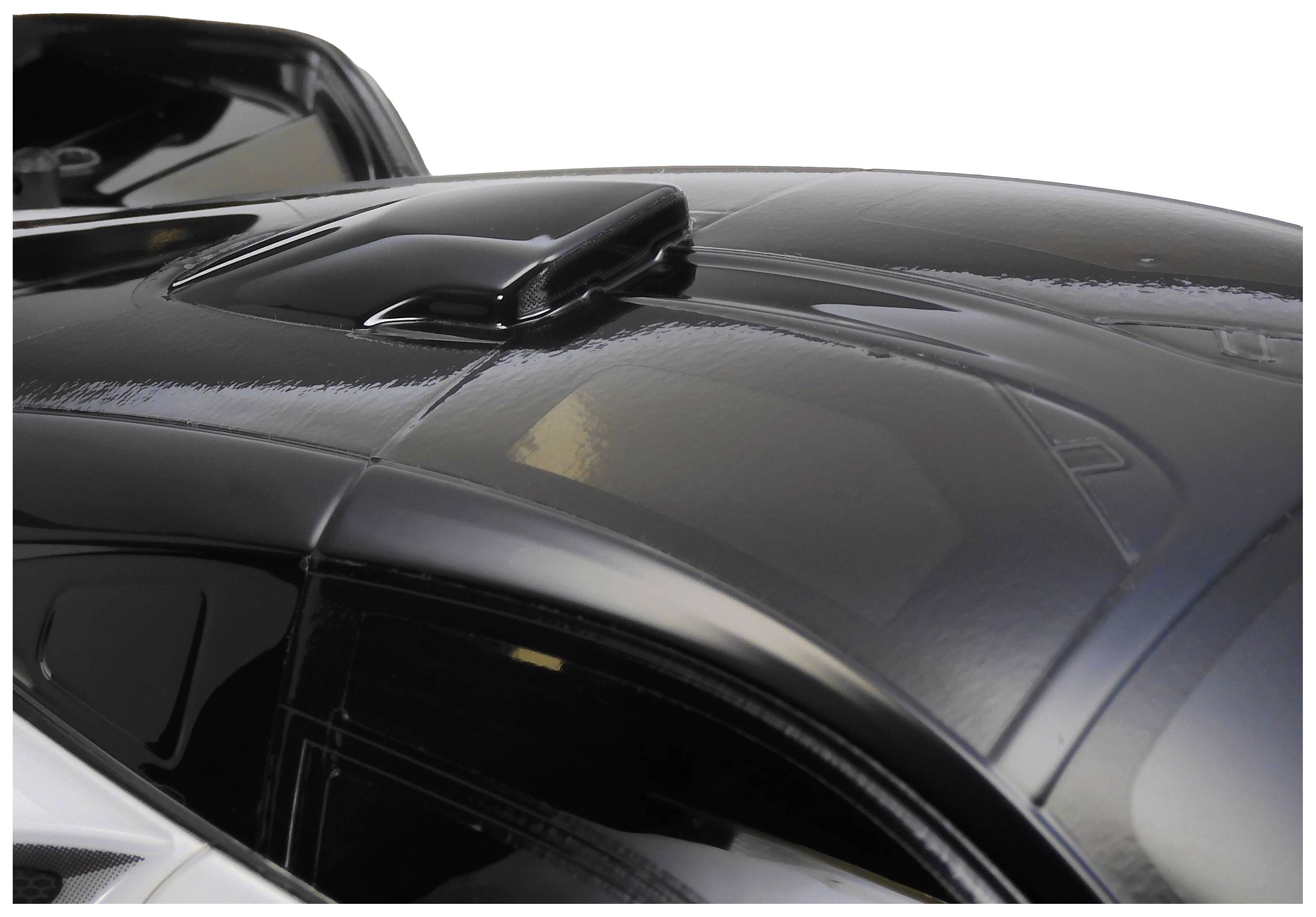 Close-up of a black toy car showcasing a distinctive roof design with a small spoiler.
