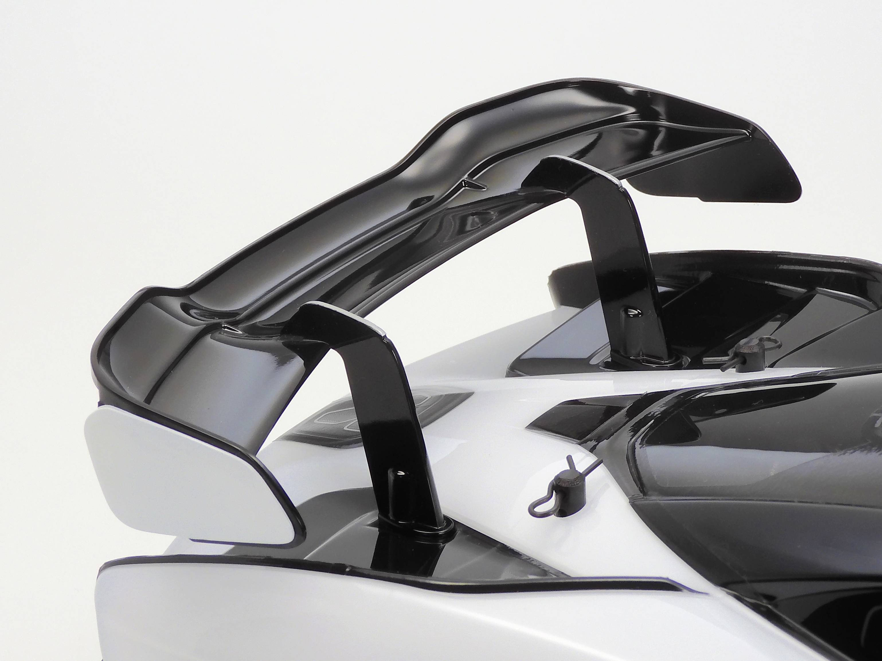 Rear spoiler of a white sports car with black details.