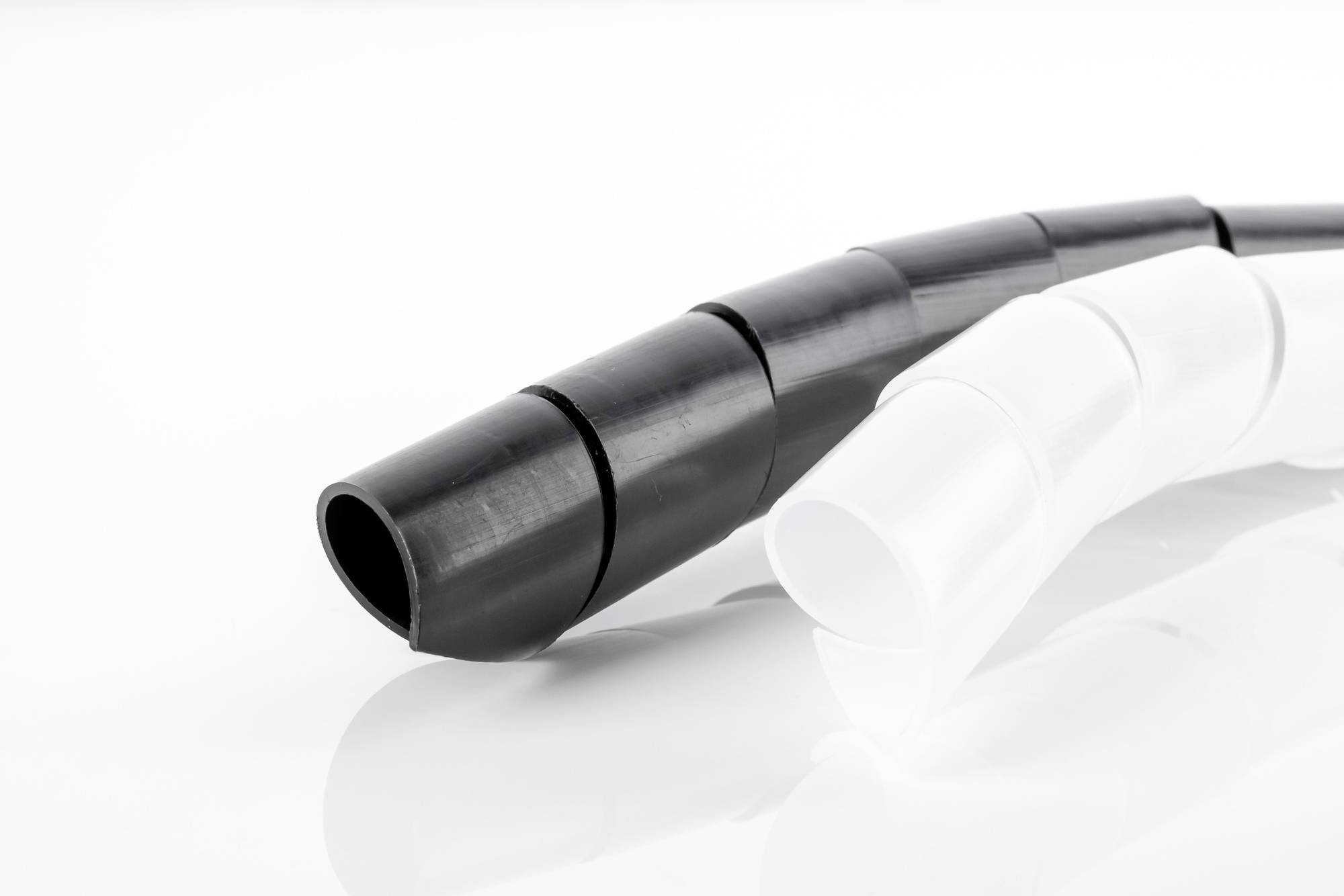 Black and white flexible cable protection sleeves on a white background.