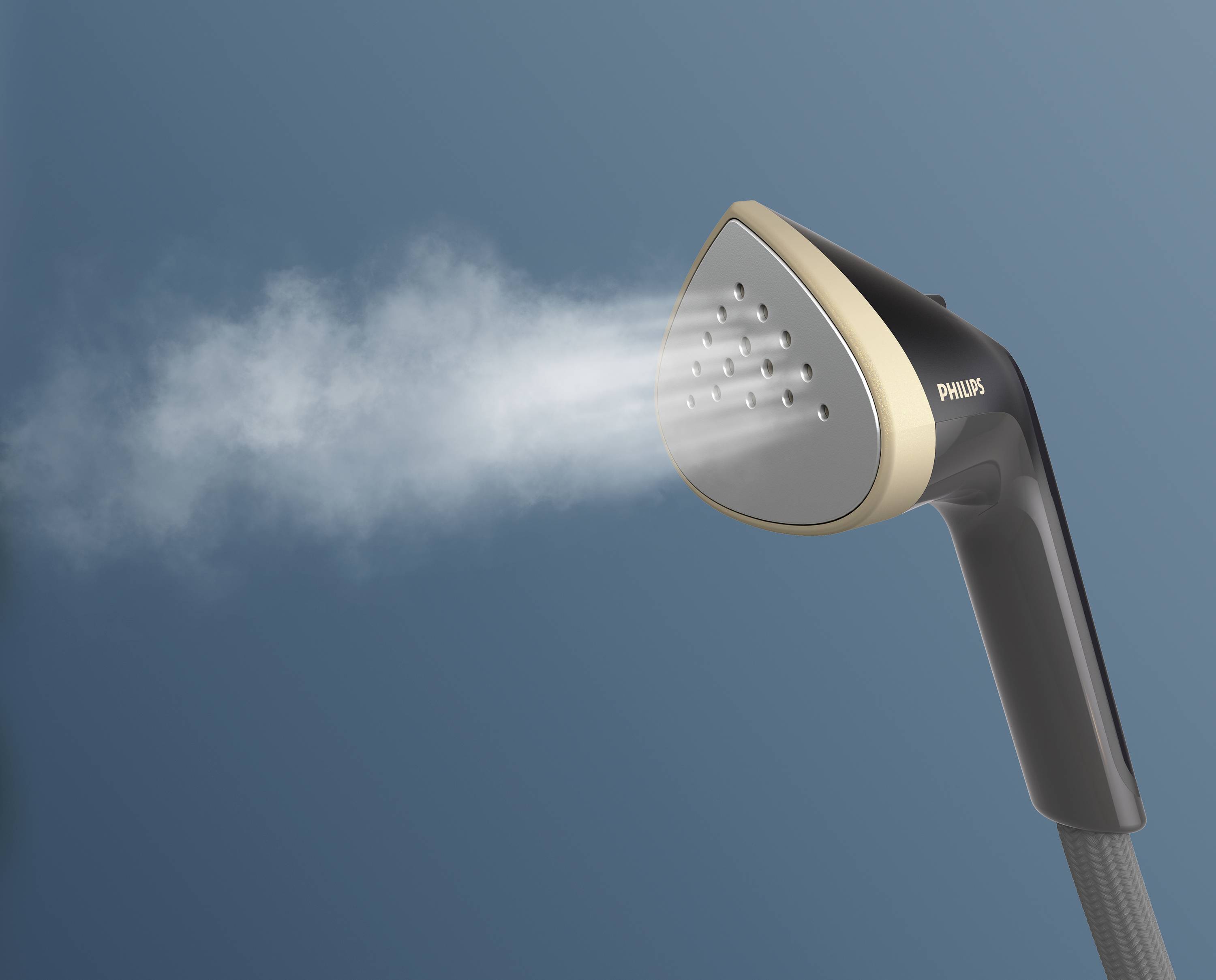 Handheld steam iron, releasing steam, on a blue background. The device is black with golden accents, suitable for smoothing clothing.