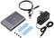 External hard drive enclosure with USB and network cable, power supply, thermal pads and screws for mounting and cooling a hard drive.