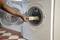 A person places a printed fabric roll into the drum of a washing machine. The washing machine door is open.