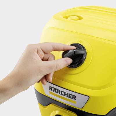 A hand turns the knob of a yellow Kärcher device.
