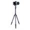 A camera mounted on a black three-legged tripod against a white background.