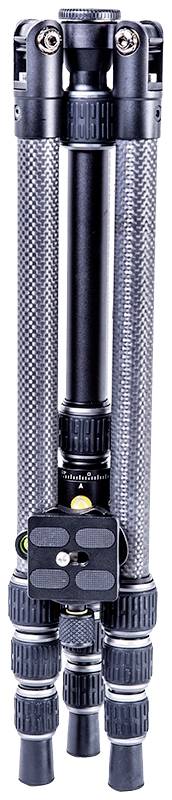 A folded, black tripod with multiple locking elements and a green spirit level on top.