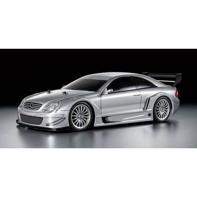 Silver racing car in profile with aerodynamic bodywork and rear spoiler against a grey background.