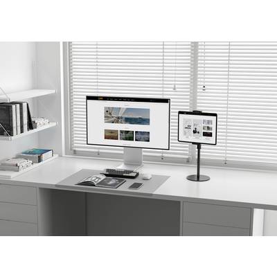 Modern desk with monitor, tablet and books. The monitor displays a website with images, the tablet another picture.