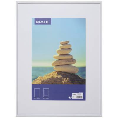 A stack of eight smooth stones on a rock against a blue sky and sea in the background.