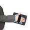 A hand in a suit holds a tablet with an elastic mount. Blue arrows indicate a rotational movement of the tablet.