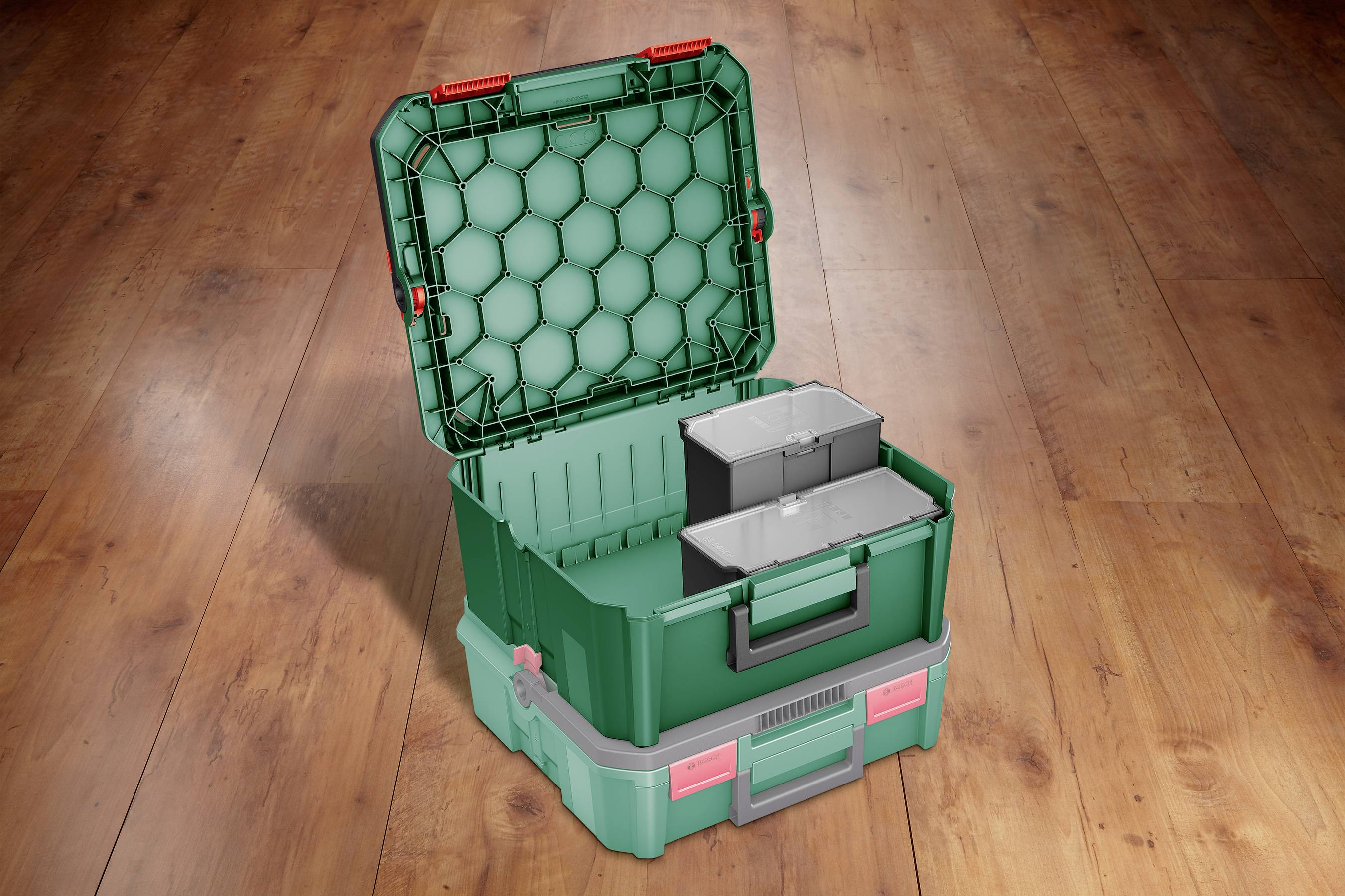 Green toolbox with an open lid and removable inserts, standing on a wooden floor.