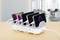 Several smartphones are being charged simultaneously at a charging station. A blurred office can be seen in the background.