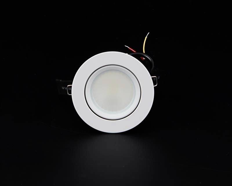 A white circular LED ceiling recessed spotlight with cables, shown against a black background.