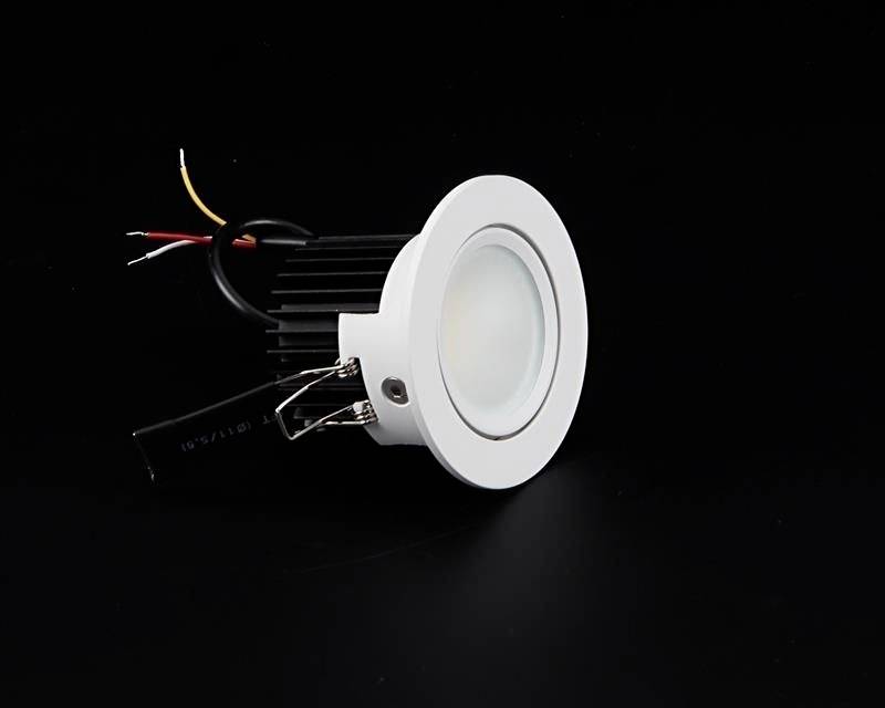 A round, white LED recessed spotlight with cables on a black background.
