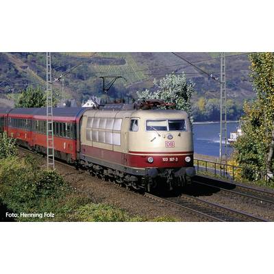 A red and beige Deutsche Bahn train travels along a route through a scenic landscape with hills and trees.