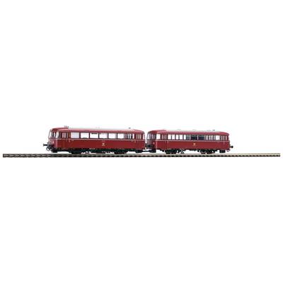 Two red model trains are travelling on parallel tracks.