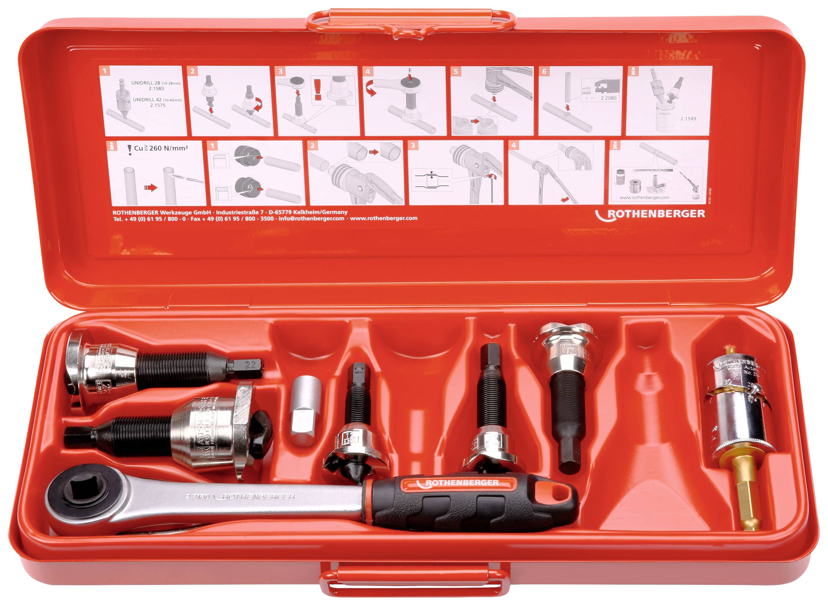 Red toolbox with multiple tools, including a spanner, pliers, and nozzles, on a red tray. Instruction diagram on the lid.