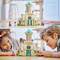 Two children are playing with a colourful model of a castle on the floor. They appear focused and creative in their imagination.