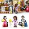 Three Lego figures in a historical setting: a man with a book, a woman with a cake, and another woman beside her. A kitchen with pots and a fireplace in the background.