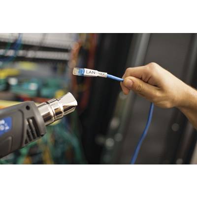 A hand holds a 'LAN-107' cable in front of a device in a server room. Connections and hardware are visible in the background.