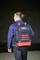 A person is wearing a black and red rucksack from the brand 'Wiha'. They are wearing a blue jacket and black trousers.