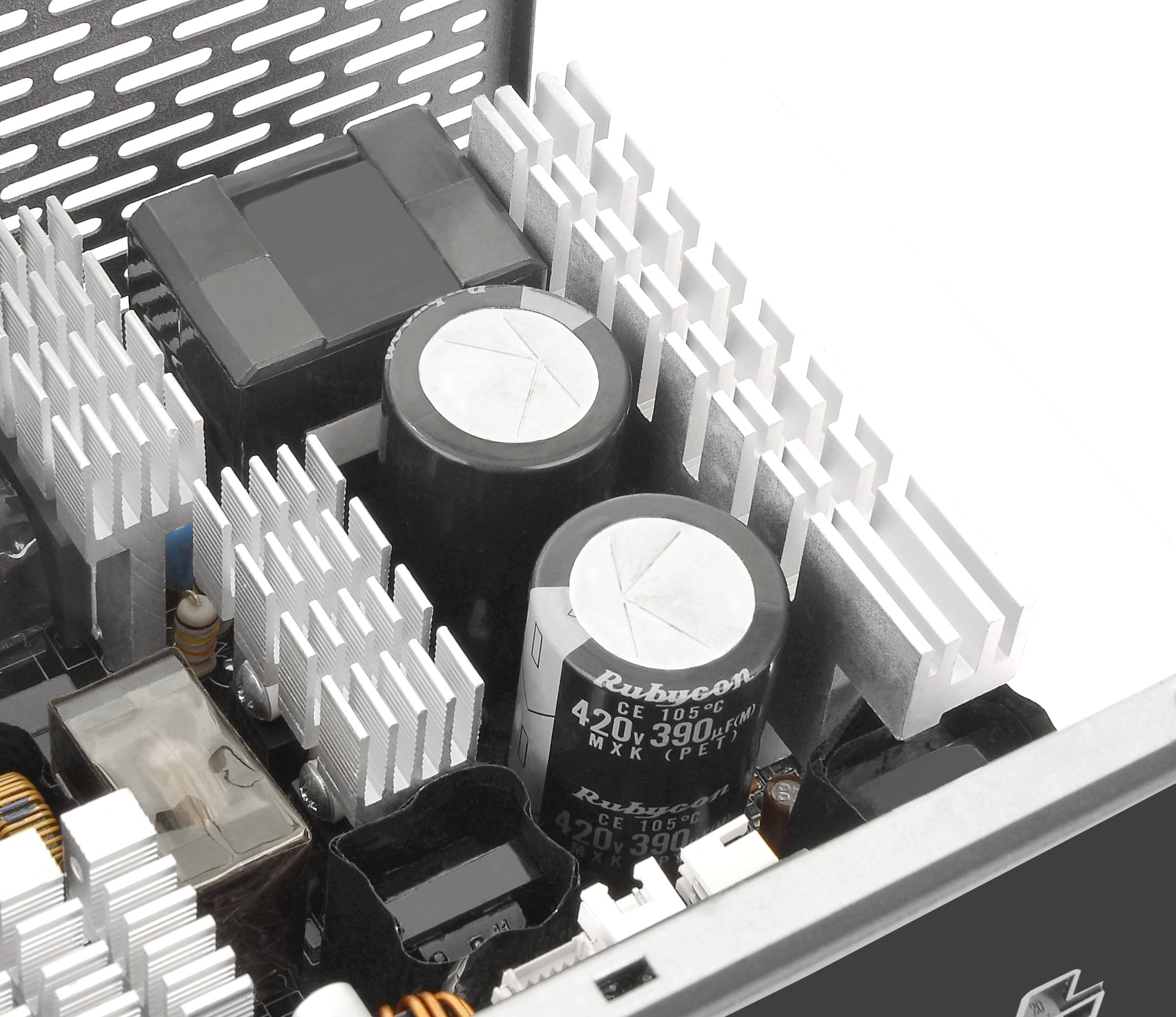 Close-up of a computer power supply unit, showing capacitors and heat sinks that provide electrical stability and cooling.