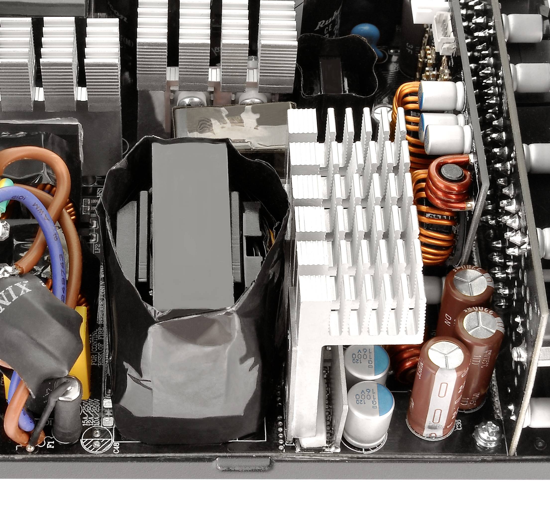 Close-up of a computer power supply with heat sinks, cables, and capacitors, showing the internal electronics and components of a power supply unit.