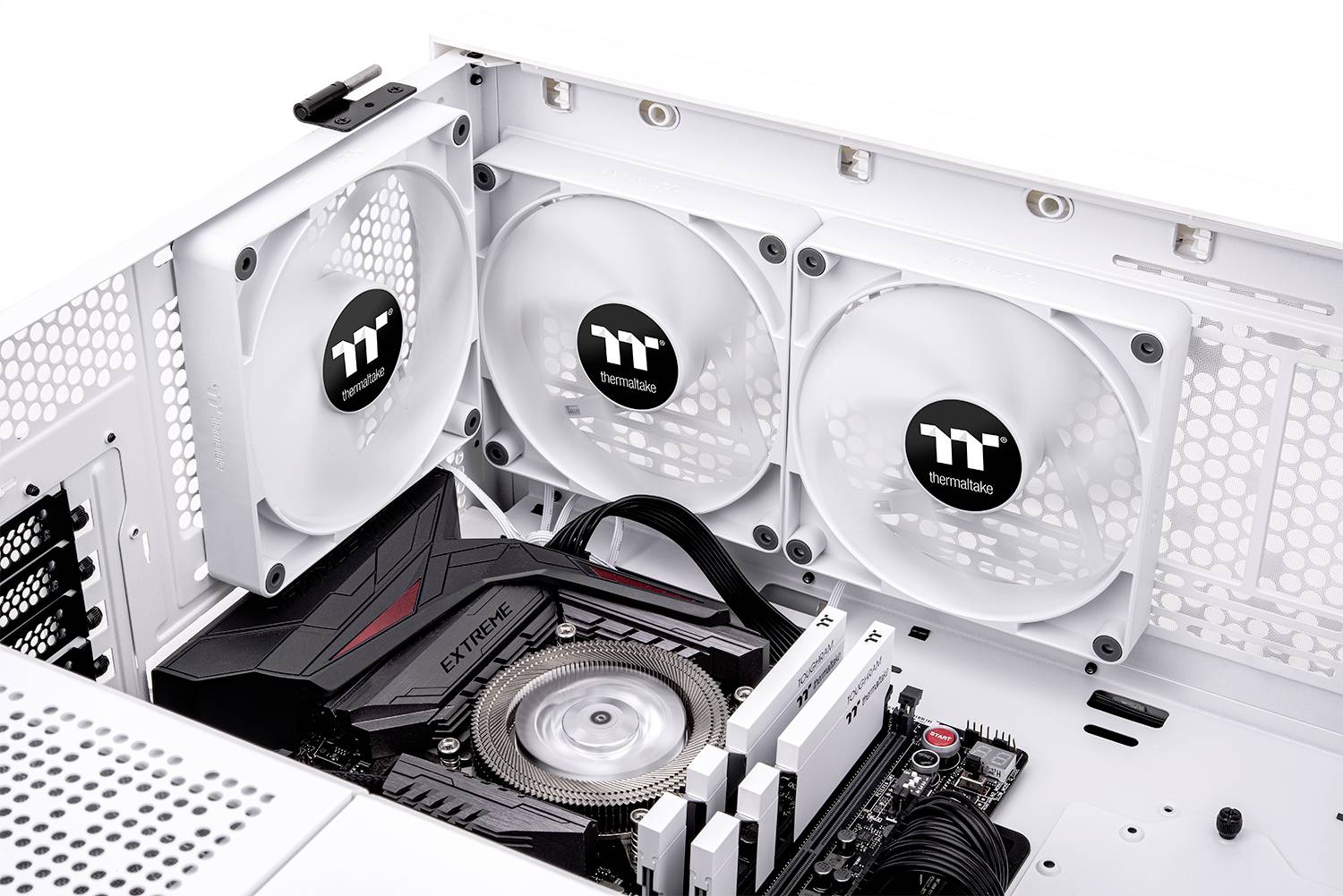 An open computer case reveals three white fans and a black motherboard with an inserted CPU fan pad inside.