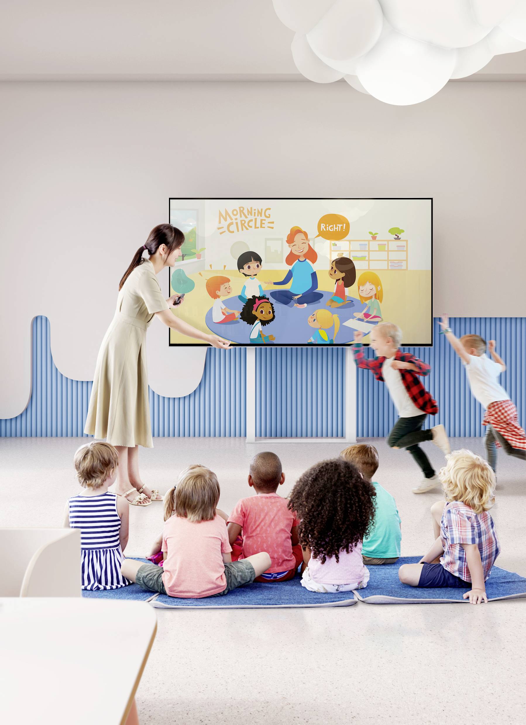 A teacher shows children a drawing on the screen with the title 'Morning Circle'. The children are listening attentively.
